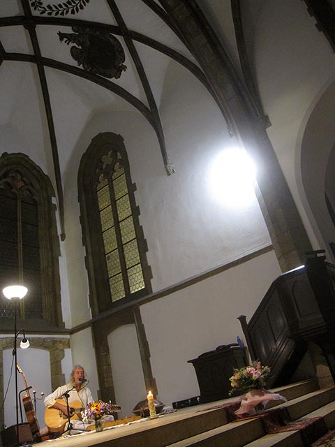 Konzert von István Sky in der St.-Martins-Kirche in Prag. 06.10.2023. István mit Gitarre. Kirchliche Gewölbe.