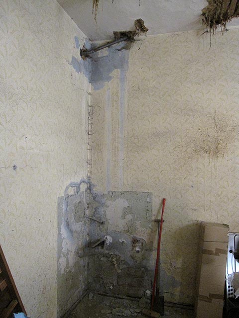 Внизу и вверху угла канализационные трубы.