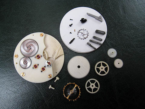 Fein gearbeitete Uhrenteile, Brücken aus Elfenbein, Zahnräder, goldene Schrauben, Unruh.