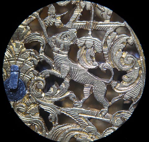 Detail eines Motivs der skelettierten Unruhbrücke. Antike Tischuhr mit Spindelhemmung, angetrieben durch Fusee (Schnecke) und Kette.