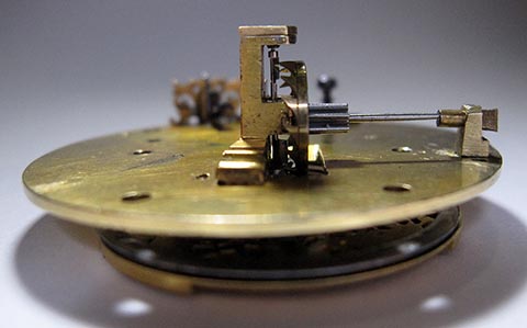 Die Paletten der Unruhwelle greifen in die Zähne des Spindelrads ein. Seitenansicht. Antike Tischuhr mit Spindelhemmung, angetrieben durch Fusee und Kette.