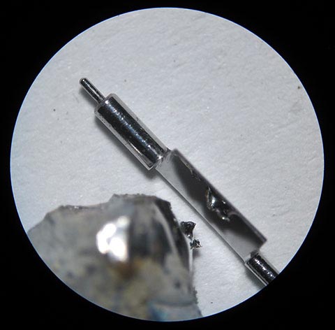 Herstellung der Unruhwelle. Ein Stück Zinn spiegelt sich in der polierten Palette der Unruhwelle. Antike Tischuhr mit Spindelhemmung.