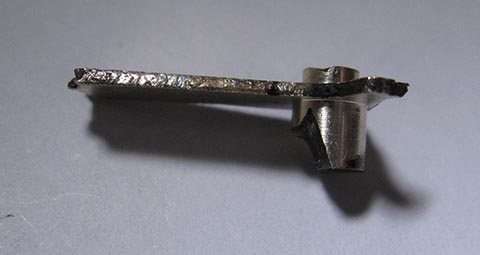 Antike Tischuhr mit Spindelhemmung. Herstellung des Stundenzeigers. An einem Ende des Rohlings beidseitig abgedrehte Zylinder. Seitenansicht.