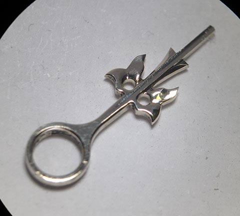 Antike Tischuhr mit Spindelhemmung. Herstellung des Stundenzeigers. Endgültig polierter und fertiger goldener Stundenzeiger.