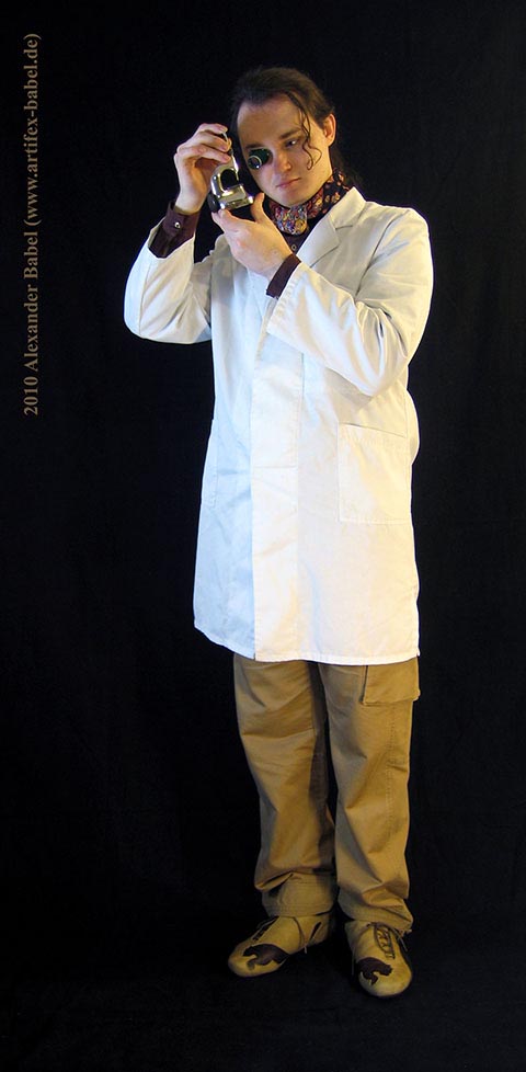 Alexander Babel in Großaufnahme, Ganzkörper, betrachtet ein Teil unter der Lupe in der Triebnietmaschine.