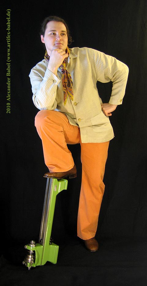 Alexander Babel in Großaufnahme, Ganzkörper, frontal. Das angewinkelte Bein steht auf der Drehmaschine Schaublin 70.