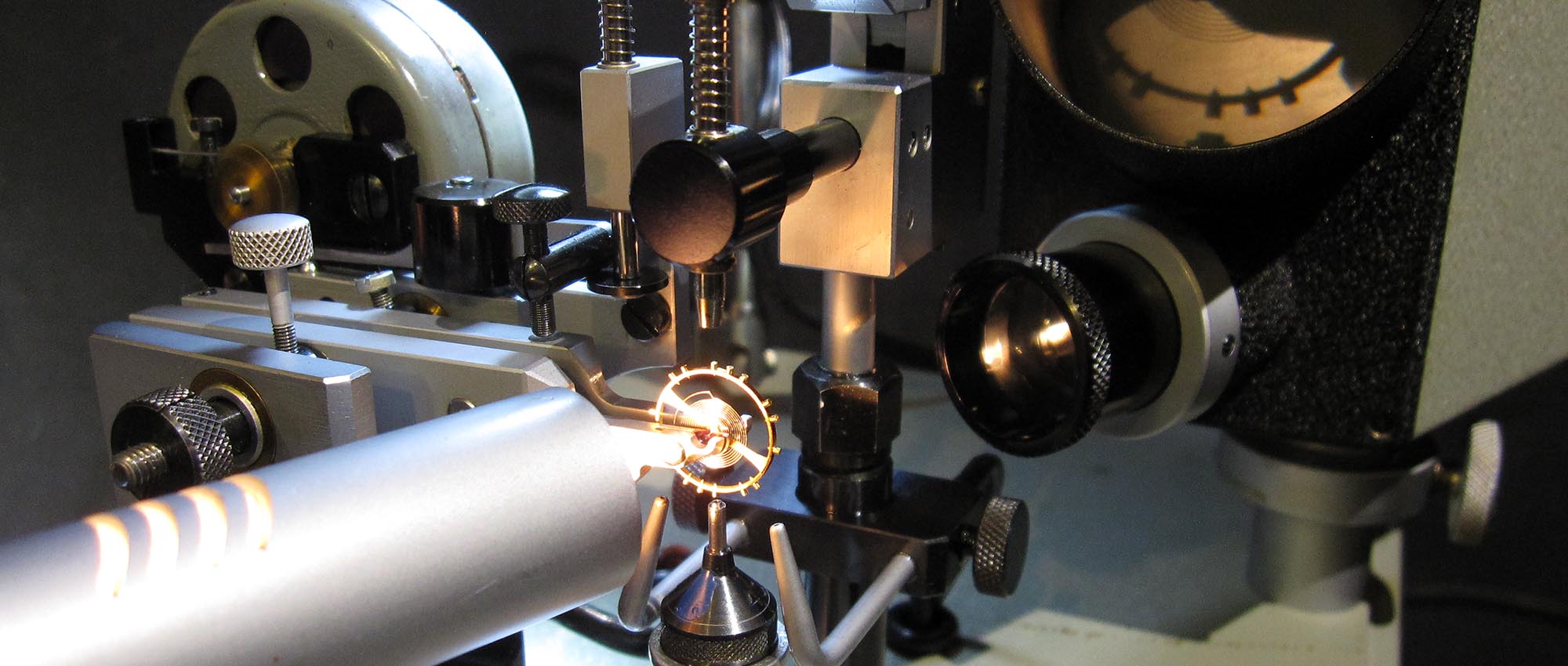 Jean Widmer-Steiner zum Auswuchten einer Schraubenunruh Typ 1. Mithilfe eines Lichtstrahls wird die schwarze Silhouette der Unruh auf einen kleinen Bildschirm projiziert.